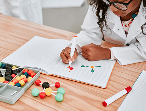 Girl drawing pictures of molecules